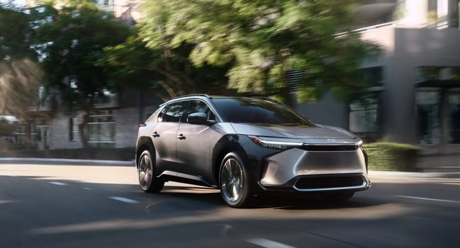 A gray 2023 Toyota bZ4X electric SUV is dirivng on the road. 