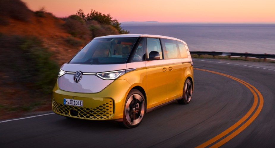 A green and white 2024 Volkswagen ID. Buzz electric minibus is driving on the road. 