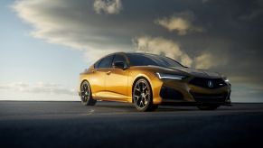 Passenger side view of a metallic yellow Acura TLX Type S driving.