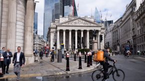 A bike courier rides through a square in London, a car-free city