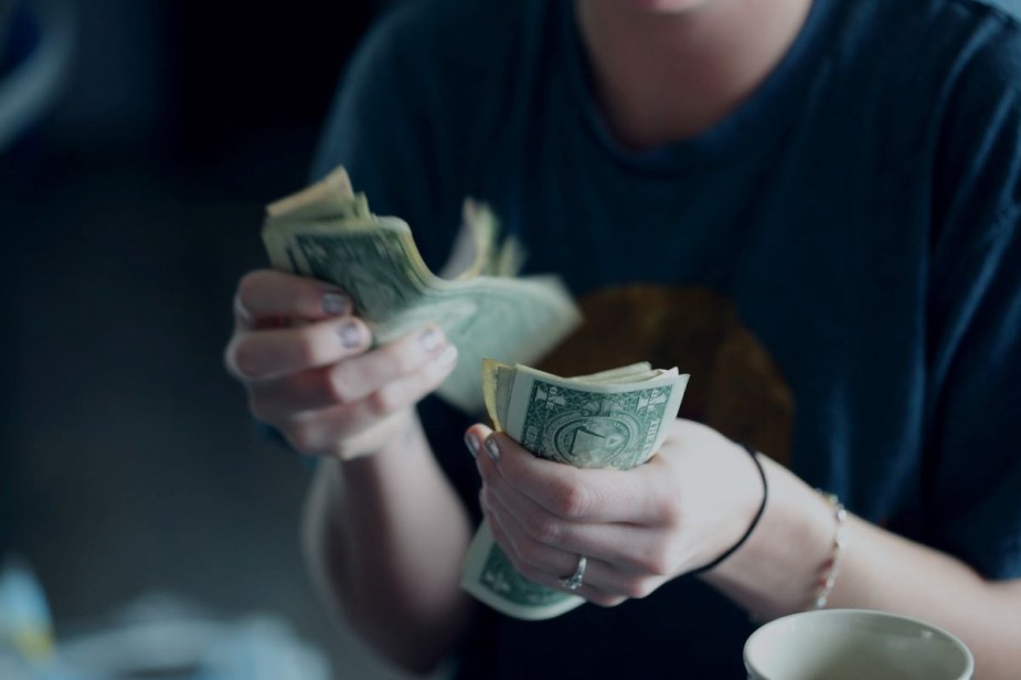 Close-up of a person counting out dollar bills