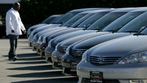 A man inspects new Toyota cars on display.