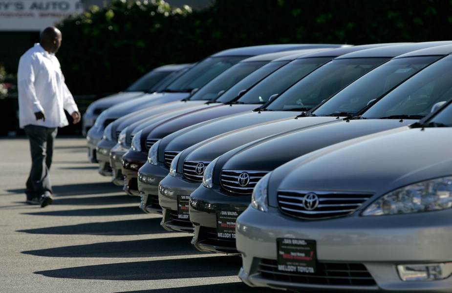 A man inspects new Toyota cars on display.