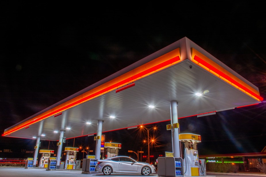 Car parked at an empty, night-time gas station.