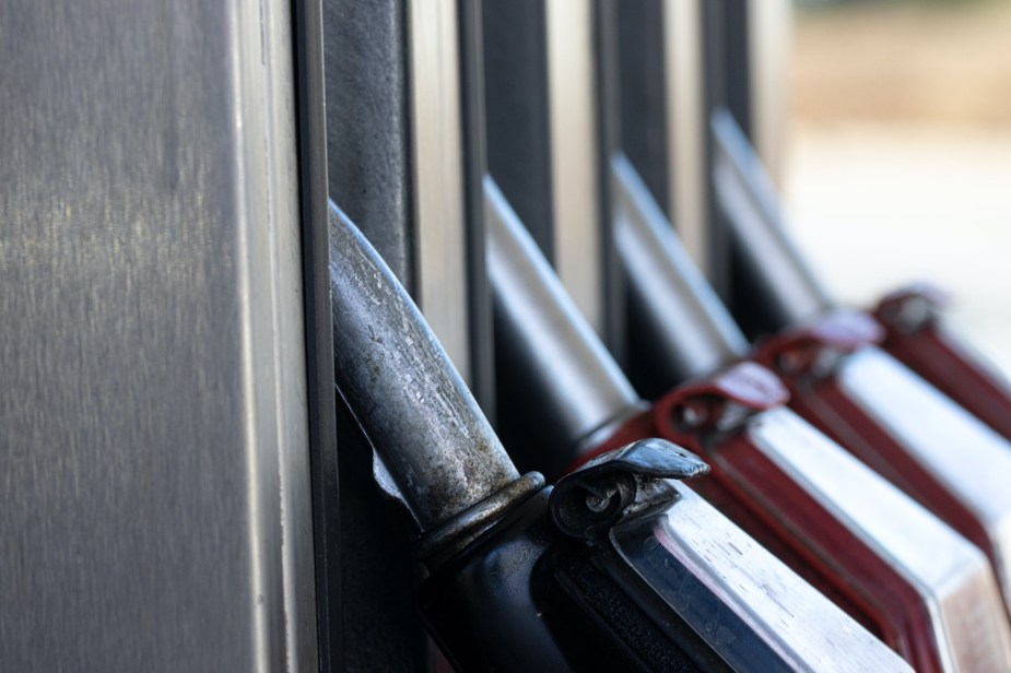 Closeup of a row of gasoline nozzles hung on a fuel pump in a filling station.