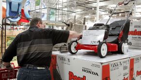 A man shopping for a lawn mower model at a Costco in Mount Prospect, Illinois