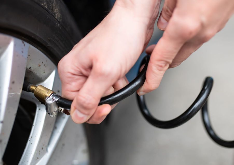 A woman checking the air pressure in her tires in Bavaria, Munich, Germany