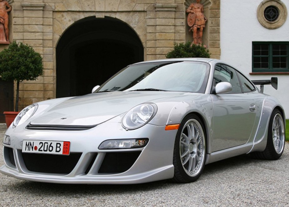 A silver 2004 RUF RGT next to a stone building