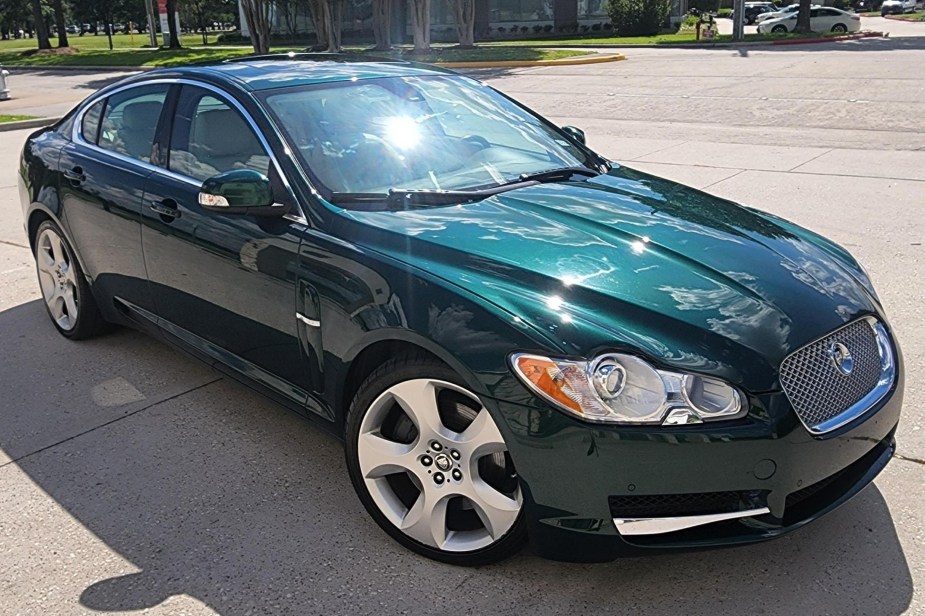 The front 3/4 view of a green 2009 Jaguar XF Supercharged in a driveway