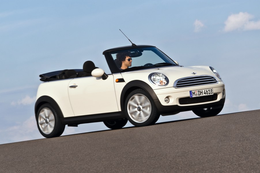 A white 2009 R57 Mini Cooper Convertible with its roof down