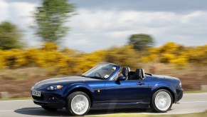 A blue 2010 Mazda MX-5 Miata sports car being driven fast