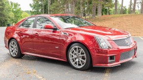 A red 2011 Cadillac CTS-V Sedan in a forest parking lot