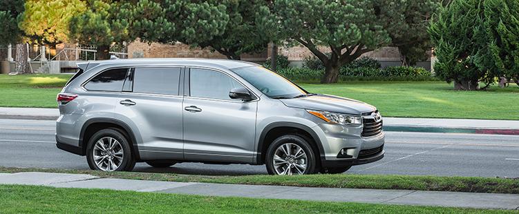 A Silver 2015 Toyota Highlander near a park