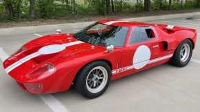 A red-with-white-stripes 2016 Race Car Replicas Ford GT40 Mk1 in a parking lot