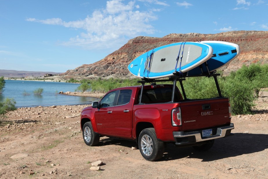 A red 2020 GMC Canyon parked near a lake.