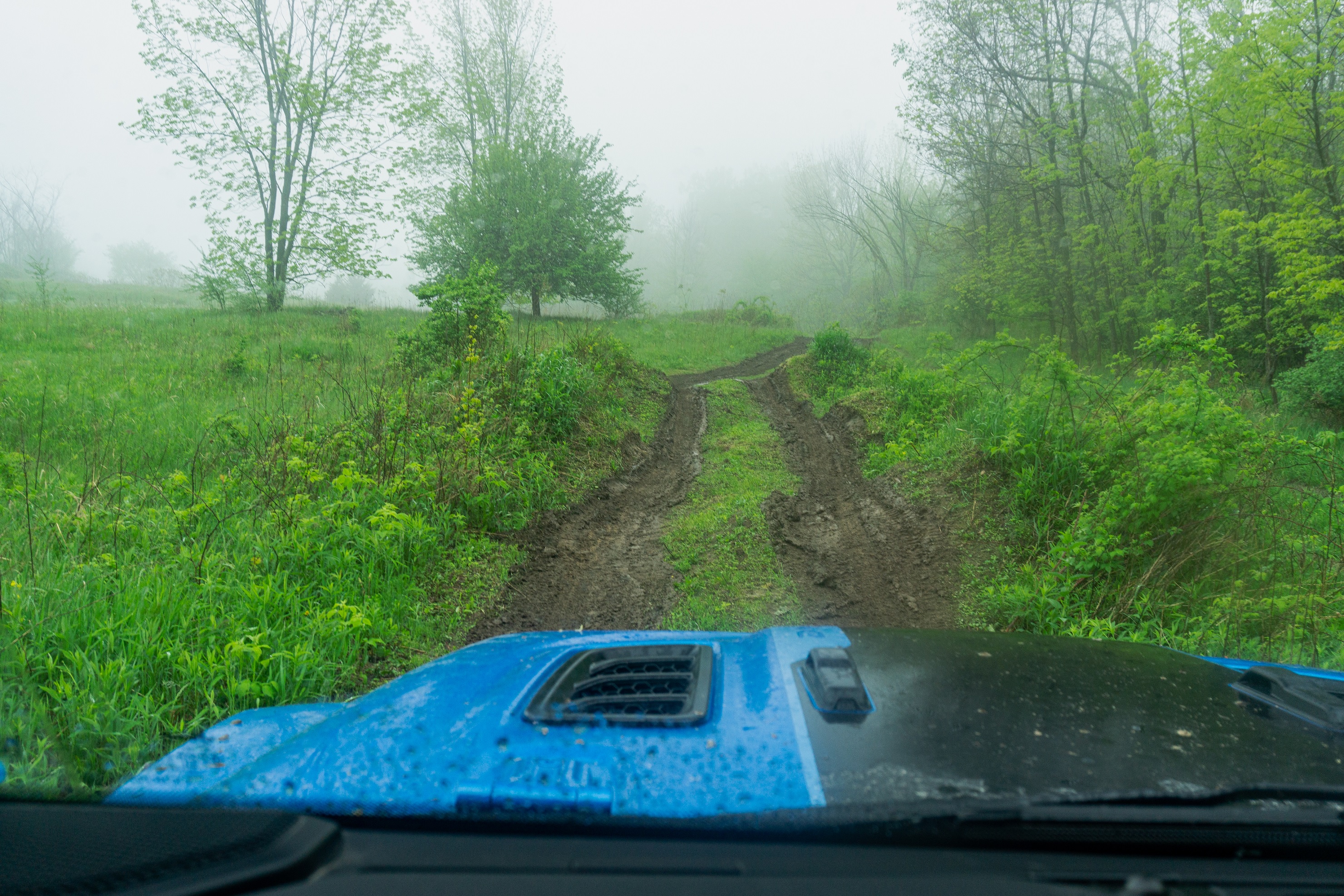 The hood of a blue 2021 Jeep Wrangler Unlimited Rubicon 4xe about to tackle an off-road articulation ramp