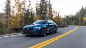 A blue 2022 Audi A3 sedan driving down a tree-lined street