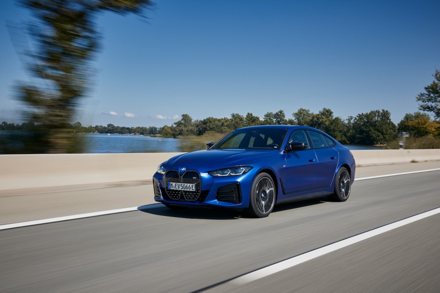 A front view of the 2022 BMW i4 driving down a road.