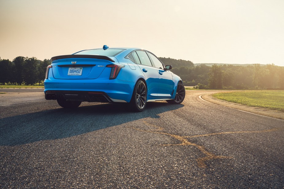 The rear 3/4 view of a blue 2022 Cadillac CT5-V Blackwing on a racetrack