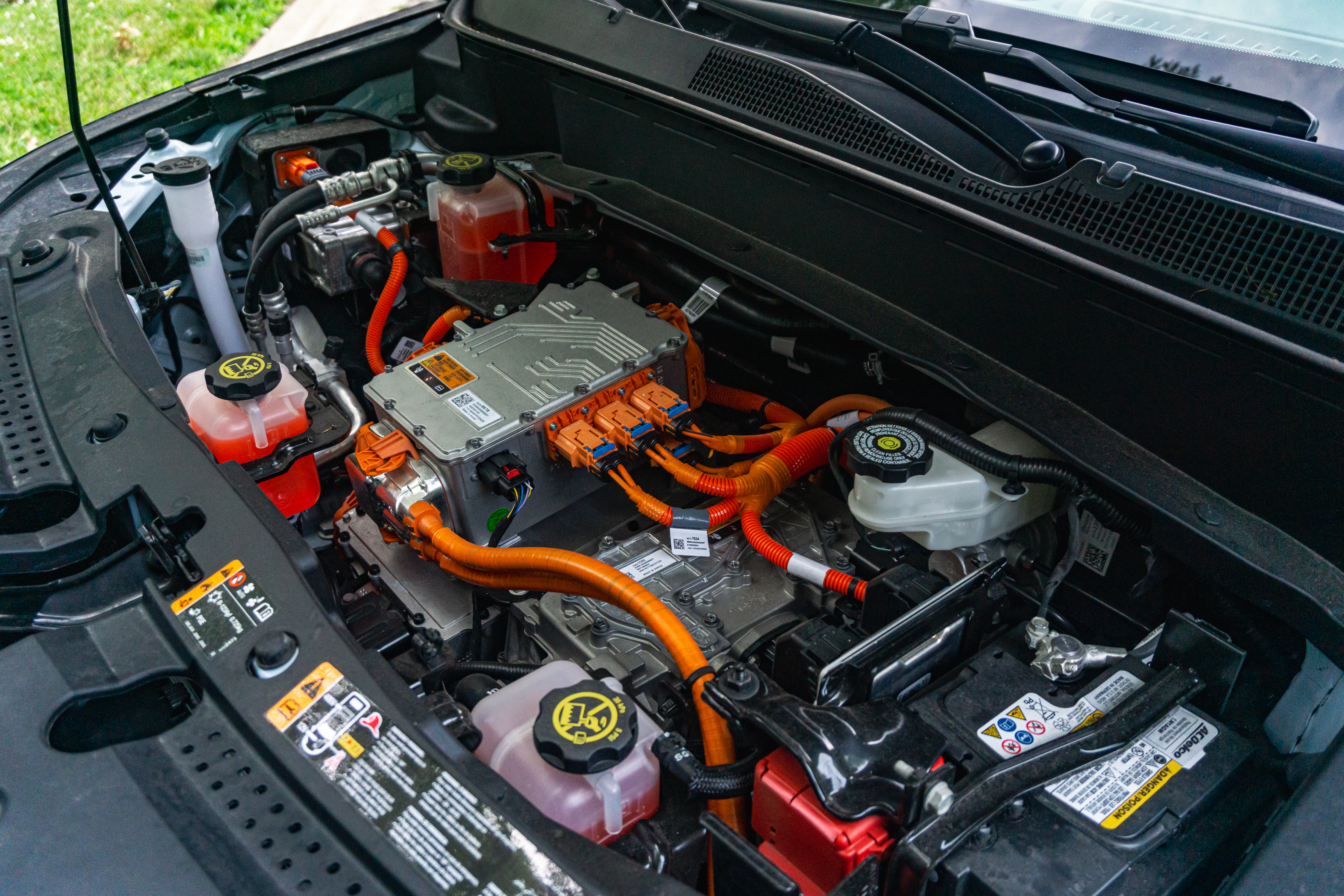 The electric motor and other hardware underneath a light-blue 2022 Chevrolet Bolt EUV Premier's hood