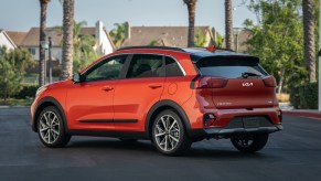 an orange kia niro parked in a neighborhood