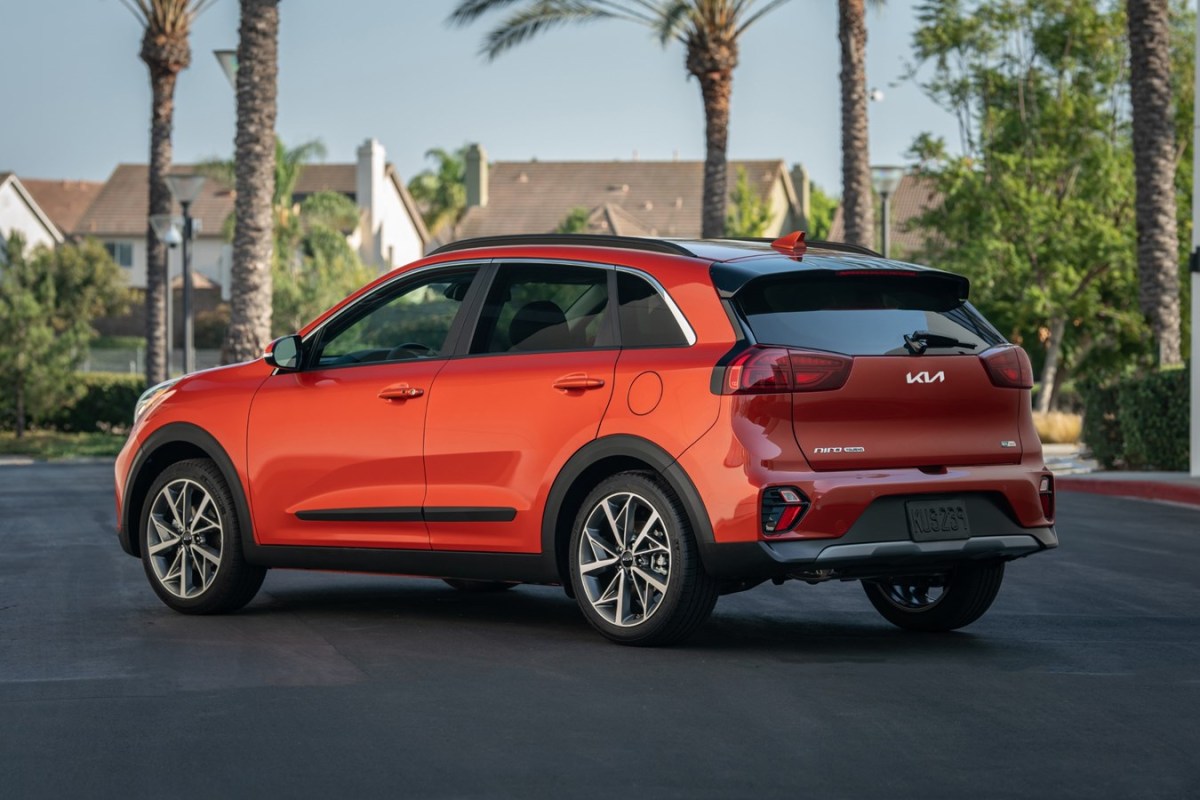 a red Kia Niro parked on a road