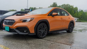 The front 3/4 view of an orange 2022 Subaru WRX Premium in the Road America parking lot