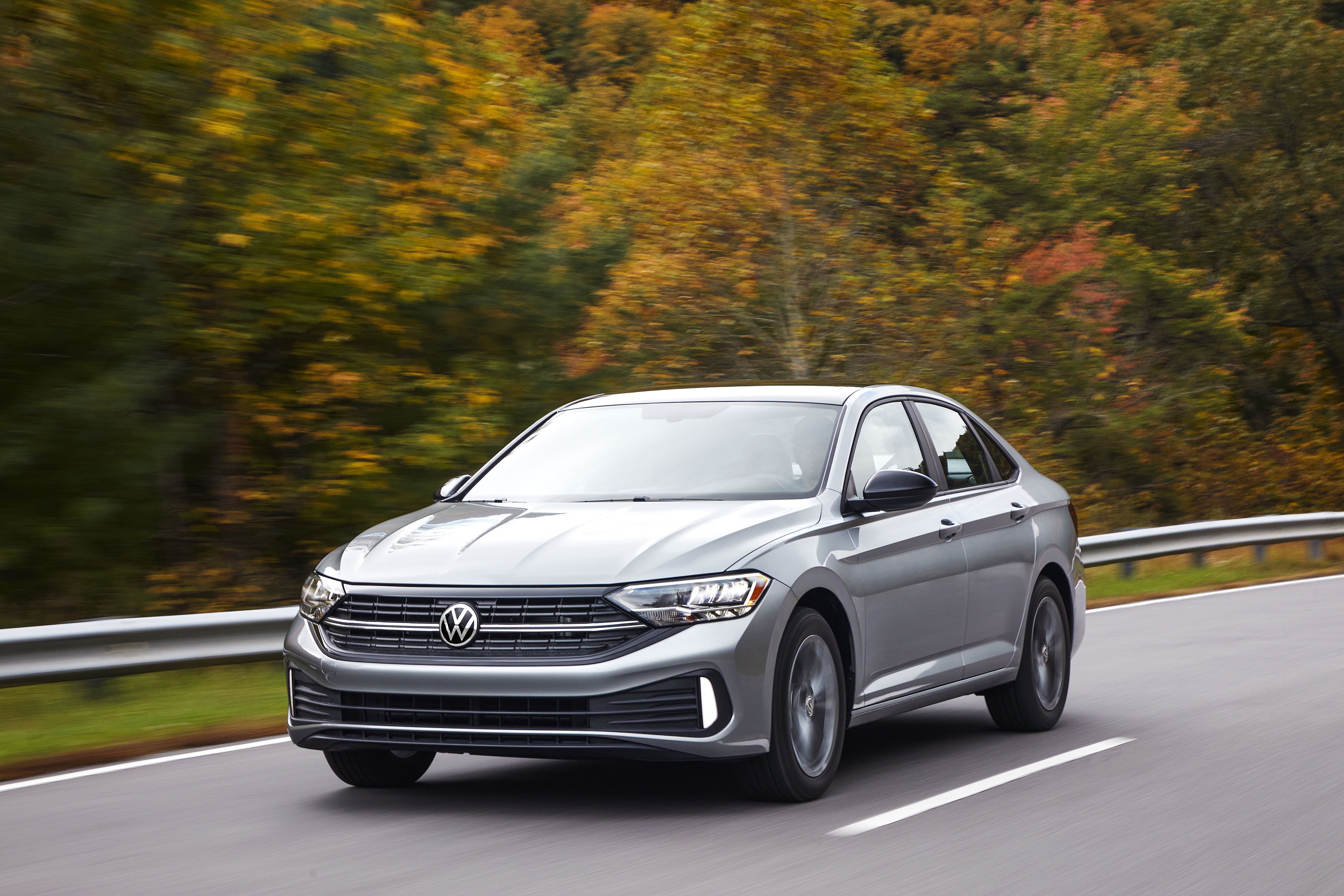 A gray 2022 Volkswagen Jetta driving on a forest road