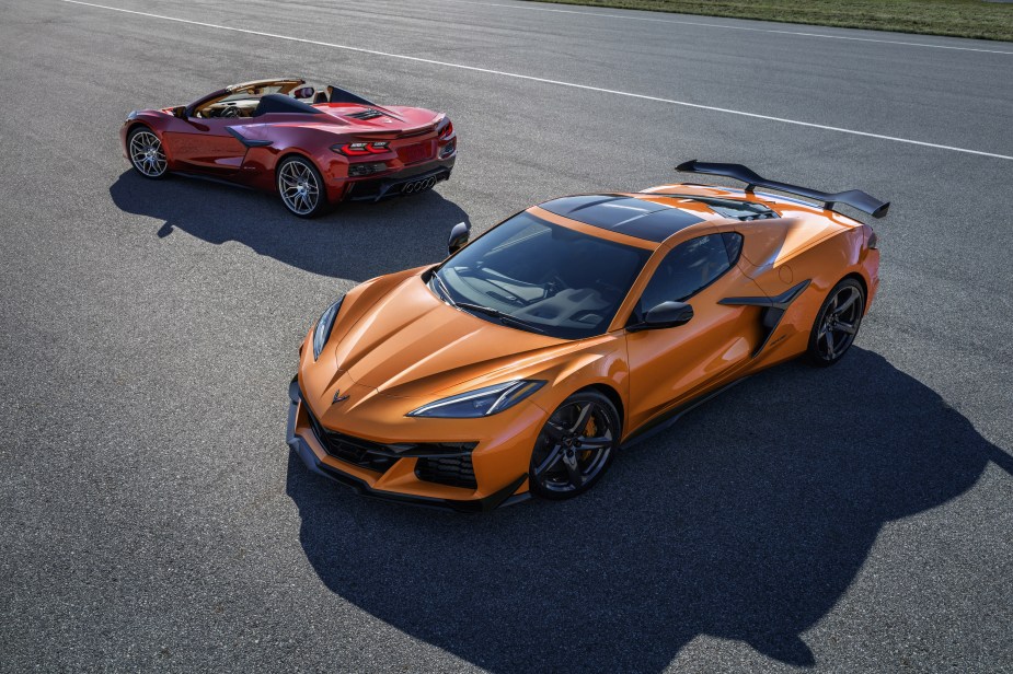 An orange 2023 C8 Chevrolet Corvette Z06 Coupe in front of a red Convertible on a racetrack