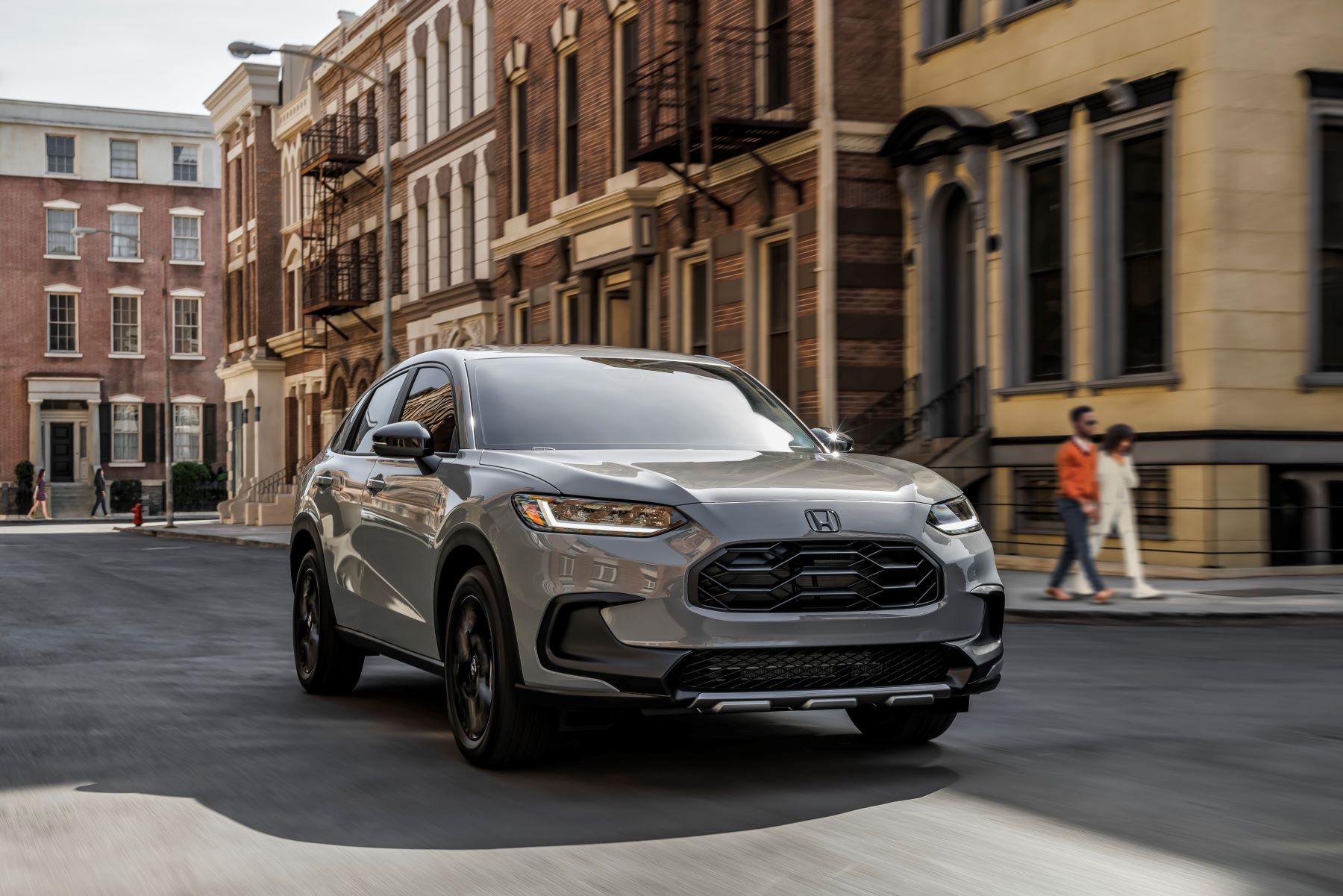 A gray 2023 Honda HR-V Sport subcompact SUV model driving through a city