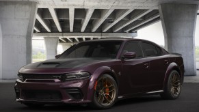 A purple 'Funky Monkey' 2022 Dodge Charger SRT Hellcat Redeye Widebody Jailbreak Edition under a concrete bridge