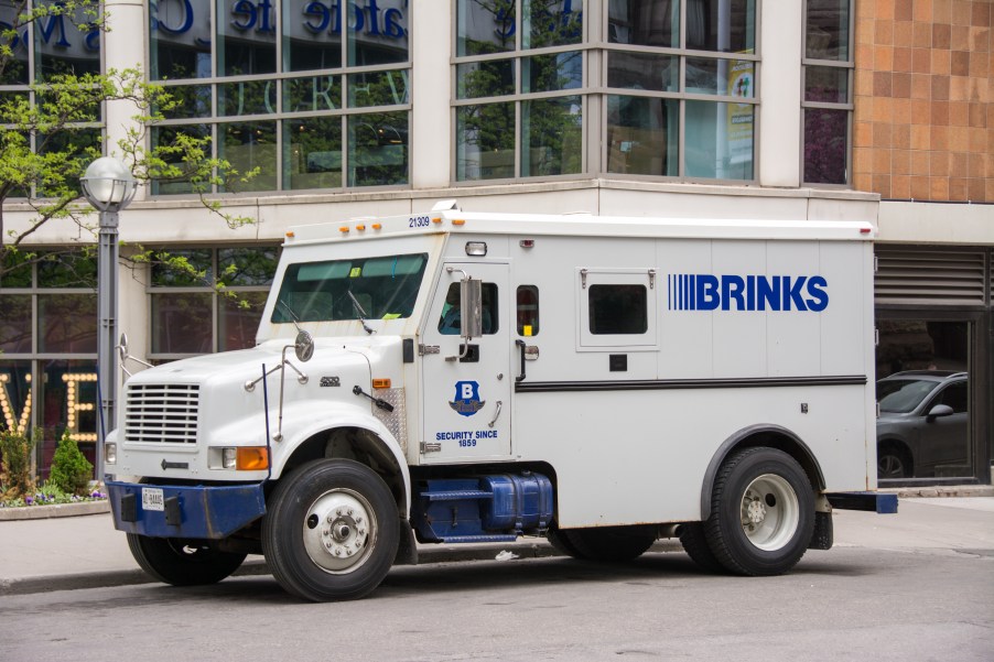 White Brinks armored security truck parked in front of a building