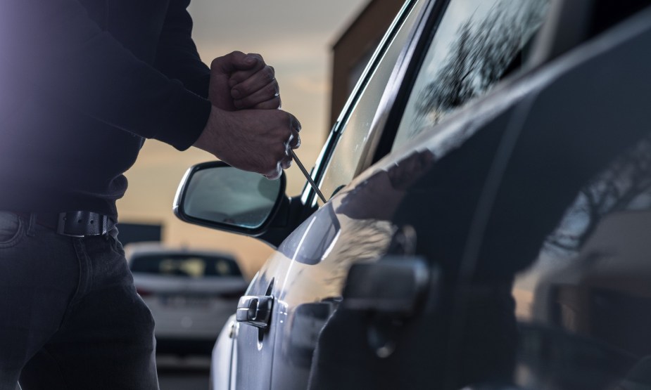 Car Theft in Progress thief with a tool attempting to steal a car