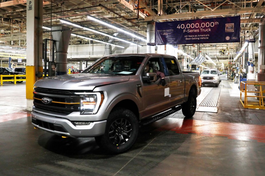 A silver Ford truck inside of the Ford factory. 