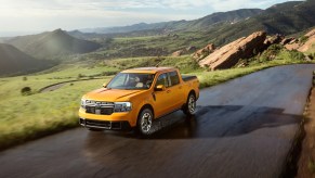 A yellow 2022 Ford Maverick drives on an area road.