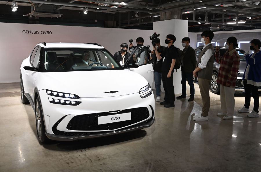 A white Genesis GV60 parked indoors.