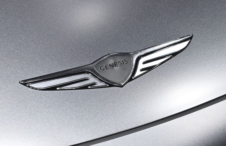 A silver 2023 Genesis GV60 logo on a silver car.