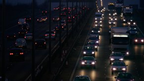 Cars driving down a highway with many different types of headlights.