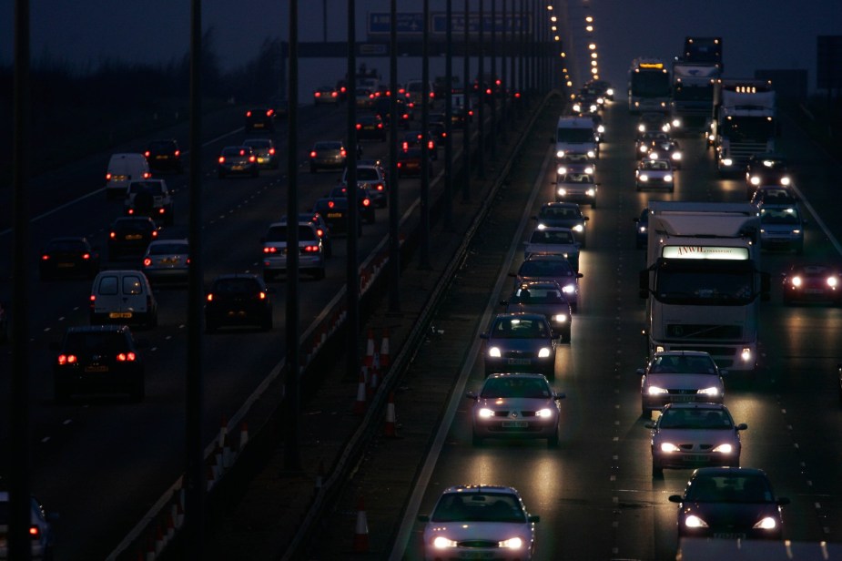 Cars driving down a highway with many different types of headlights. 