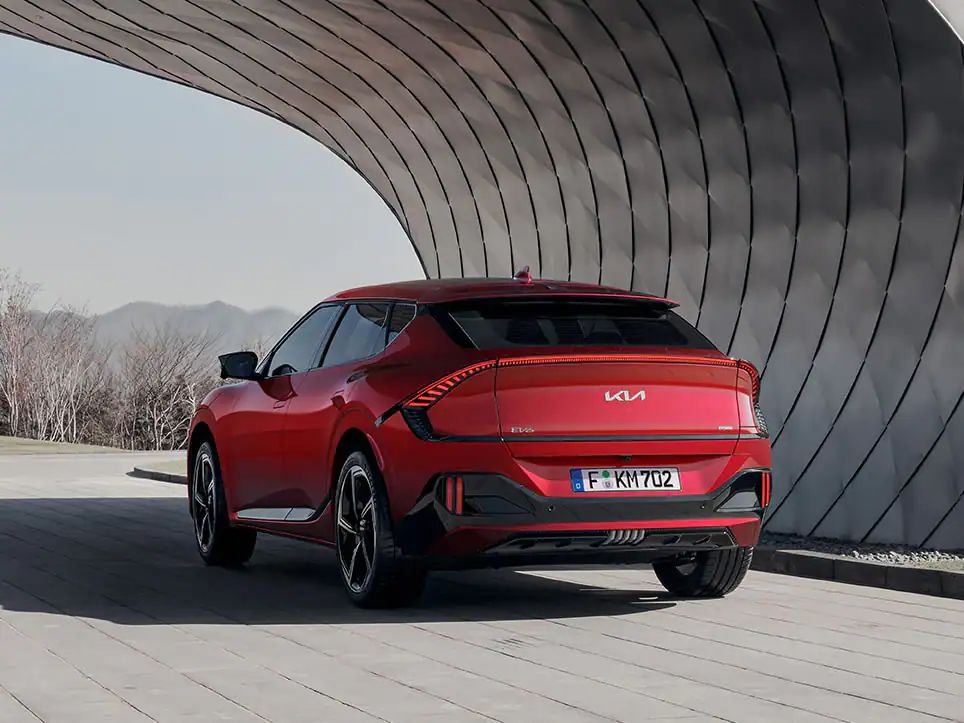 A red 2022 Kia EV6 GT drives on a local road.