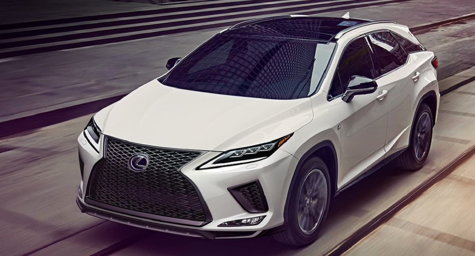 A white Lexus RX350 luxury midsize SUV is driving on the road.