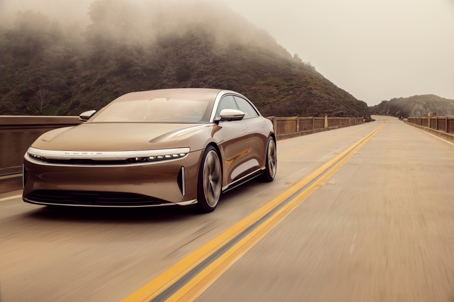 The Lucid Air, like this one, cruises down a back road.