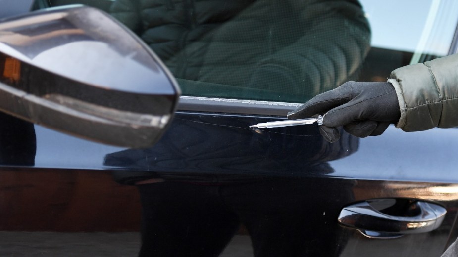 a man scratching a car with a screwdriver, remove a scratch right from home 