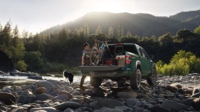 A man loads the bed of his 2022 Nissan Frontier. How much is one of these midsize pickup trucks?