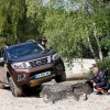 A burgundy colored Nissan Navara-R driving over a rock.