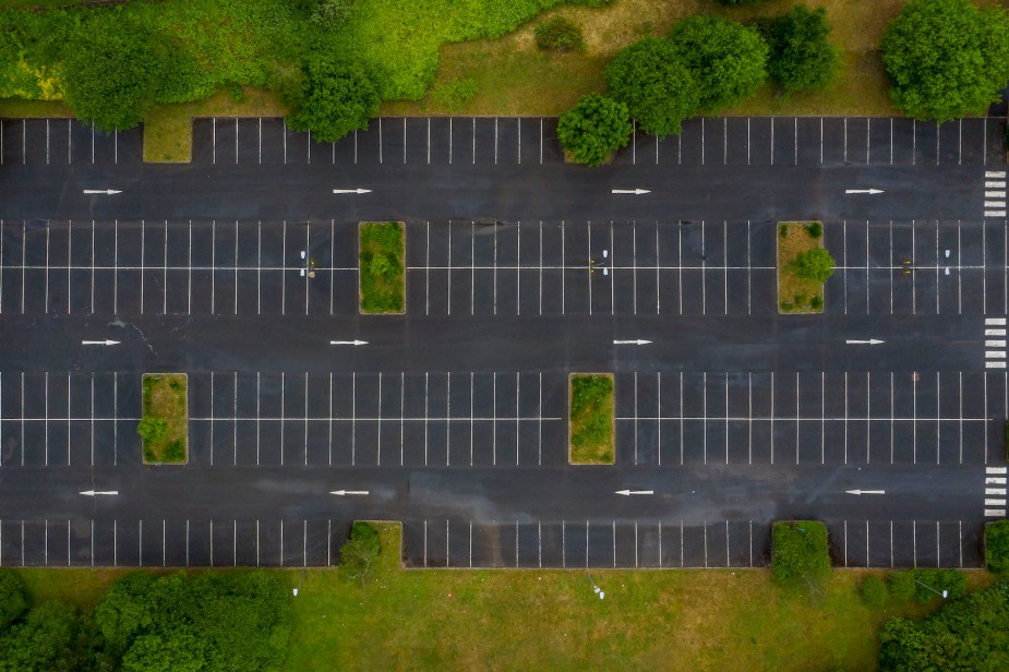 An empty parking lot with multiple parking spots where people could save your parking spot.