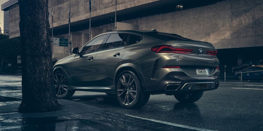 Rear angle view of gray 2023 BMW X6 shows its sloping roof line that robs the rear of cargo space. 