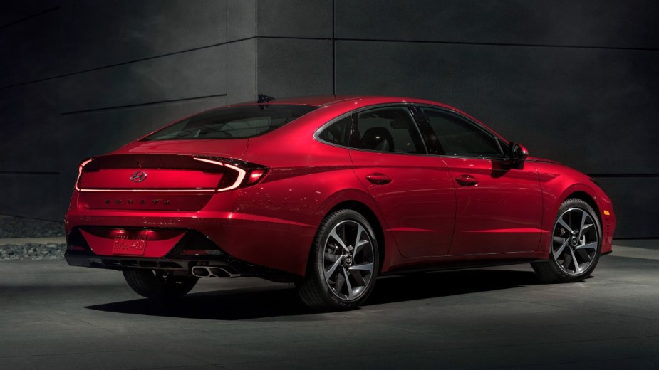 Rear angle view of red 2023 Hyundai Sonata midsize sedan, highlighting its release date and price