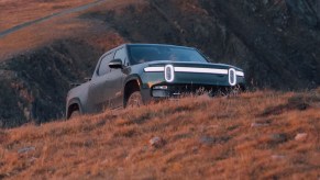 A green Rivian R1T electric pickup truck is parked outdoors.