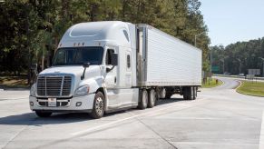 A white semi trucker potentially having a place where truck drivers sleep.